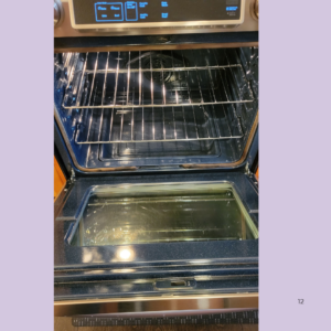 Open oven with two chrome wire racks extended, empty oven cavity ready for use.